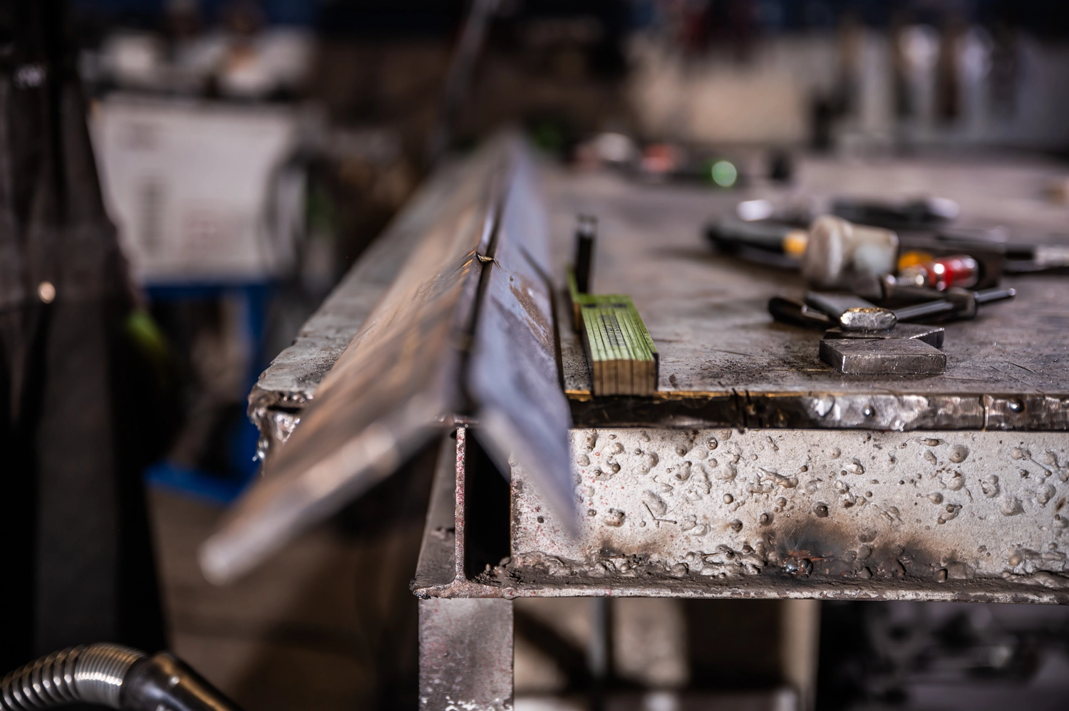 Körfgen - Schlosserei - Dieses Bild zeigt ein Werkstück, das während eines Metallbearbeitungsprozesses in einen Fräsmaschinenschraubstock eingespannt ist.